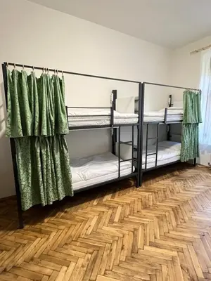 a room with two bunk beds with green curtains at Hostel DO-RE-MI in Prague