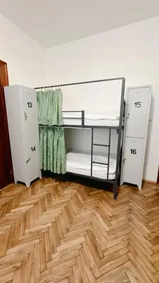 two bunk beds in a room with a wooden floor at Hostel DO-RE-MI in Prague