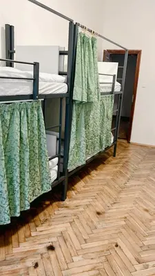 a row of bunk beds in a room with a wooden floor at Hostel DO-RE-MI in Prague