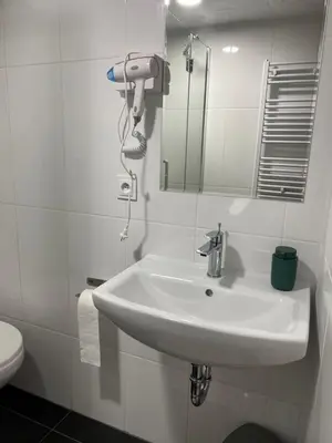 a bathroom with a white sink and a mirror at Hostel DO-RE-MI in Prague