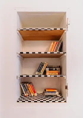 a cabinet filled with books sitting on shelves at Hostel DO-RE-MI in Prague