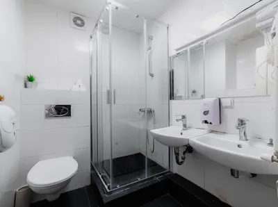 a bathroom with a shower and a sink and a toilet at Hostel DO-RE-MI in Prague