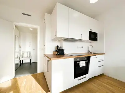 a kitchen with white cabinets and a wooden counter top at Vila Vinice in Prague