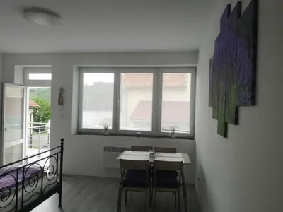 a dining room with a table and some windows at Apartmán U vody in Županovice