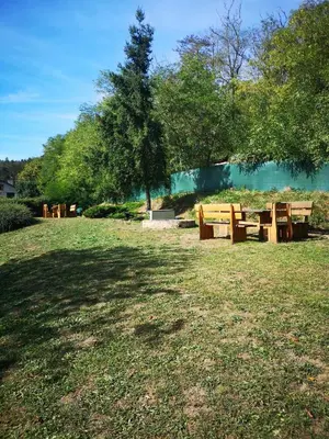 a group of wooden picnic tables in a park at Apartmán U vody in Županovice