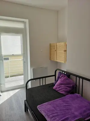 a bedroom with a bed with purple sheets and a window at Apartmán U vody in Županovice