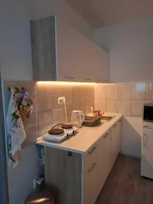 a kitchen with white cabinets and a counter top at Apartmán U vody in Županovice