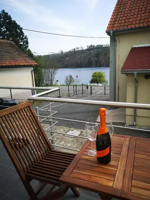 a bottle of wine and a glass sitting on a chair at Apartmán U vody in Županovice