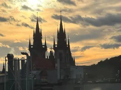 a group of buildings with a sunset in the background at Castle View Apartments. Old Town in Prague