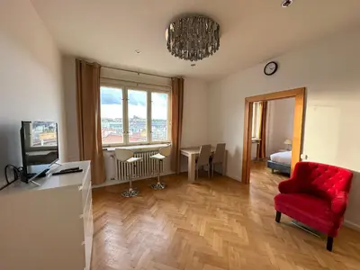 a living room with a red chair and a television at Castle View Apartments. Old Town in Prague