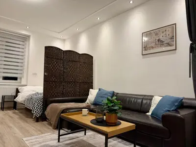 a living room with a leather couch and a table at Modern flat in Central Prague in Prague