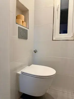 a white bathroom with a toilet and a window at Modern flat in Central Prague in Prague