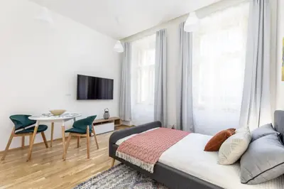 a bedroom with a bed and a table and chairs at Bright aparment close to Wenceslas square with parking in Prague
