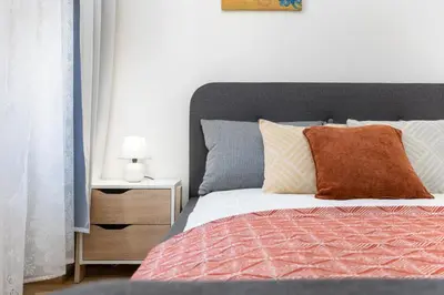 a bedroom with a bed and a night stand with a lamp at Bright aparment close to Wenceslas square with parking in Prague