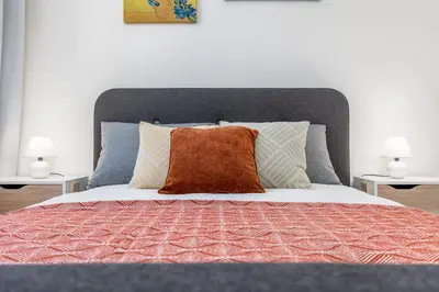 a bed with a orange pillow on top of it at Bright aparment close to Wenceslas square with parking in Prague