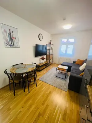 a living room with a table and a couch at Nika Apartments Prague 2 in Prague