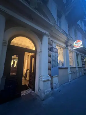 an entrance to a building at night with a neon sign at Nika Apartments Prague 2 in Prague