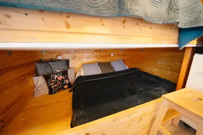 a small room with a bed in a cabin at CozyTiny house at lake with sauna in Řehenice