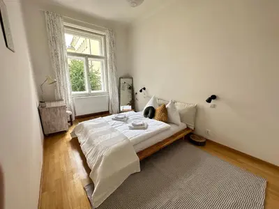 a bedroom with a large bed and a window at 3BDR Bohemian style central flat with Balcony in Prague