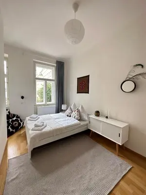 a white bedroom with a bed and a window at 3BDR Bohemian style central flat with Balcony in Prague