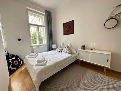 a bedroom with a white bed and a window at 3BDR Bohemian style central flat with Balcony in Prague