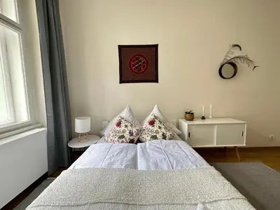 a bedroom with a white bed with pillows and a window at 3BDR Bohemian style central flat with Balcony in Prague