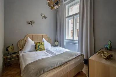 a small bedroom with a bed and a window at 3BDR Oasis in the heart of Prague in Prague