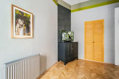 a living room with a television and a painting on the wall at 3BDR Oasis in the heart of Prague in Prague
