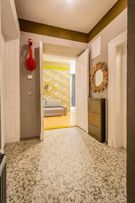 a hallway with a living room with a couch and a mirror at 3BDR Oasis in the heart of Prague in Prague