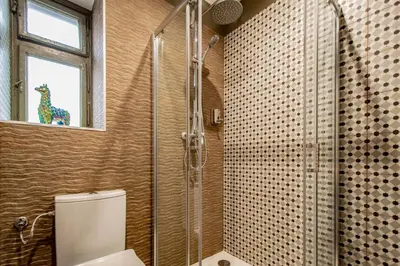 a bathroom with a shower and a toilet and a window at 3BDR Oasis in the heart of Prague in Prague