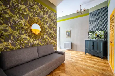 a living room with a couch and a mirror at 3BDR Oasis in the heart of Prague in Prague