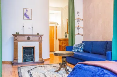 a living room with a blue couch and a fireplace at Main Prague Square apartments Sauna and Fireplace in Prague