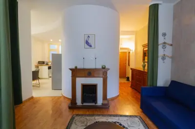 a living room with a fireplace and a blue couch at Main Prague Square apartments Sauna and Fireplace in Prague