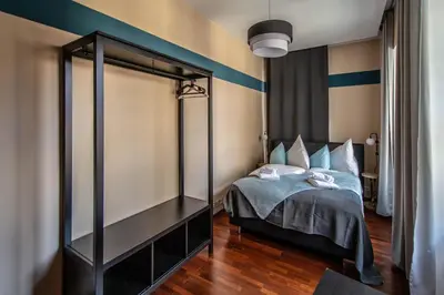 a bedroom with a bed with blue and white stripes at Wooden Design 2BDR Apartment near Eden Garden in Prague