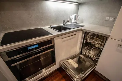 an empty kitchen with a sink and a dishwasher at Wooden Design 2BDR Apartment near Eden Garden in Prague