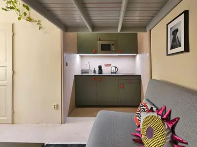a living room with a couch and a kitchen at Artistic Designer Studio Žižkov in Prague