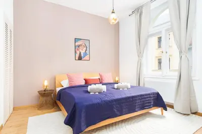 a bedroom with a bed with a blue comforter at Prague Days - Eclectic Apartment in Trendy Area in Prague