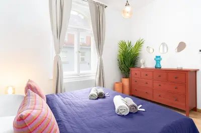 a bedroom with a blue bed with towels on it at Prague Days - Eclectic Apartment in Trendy Area in Prague