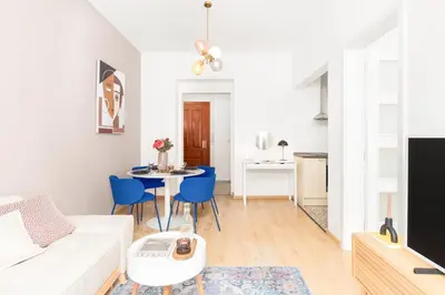 a living room with a white couch and blue chairs at Prague Days - Eclectic Apartment in Trendy Area in Prague
