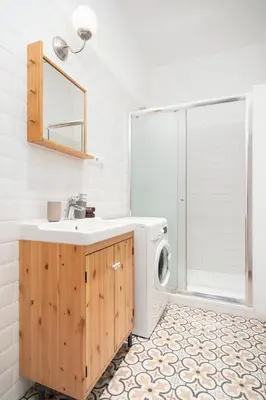 a bathroom with a sink and a washing machine at Prague Days - Eclectic Apartment in Trendy Area in Prague