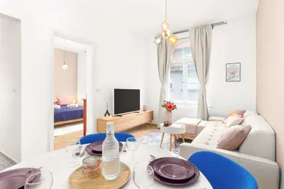a living room with a table and blue chairs at Prague Days - Eclectic Apartment in Trendy Area in Prague