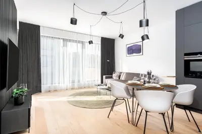 a living room with a table and white chairs at Prague Days - Premium Apartments - Balcony in Prague