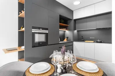 a dining room with a table and chairs and a kitchen at Prague Days - Premium Apartments - Balcony in Prague