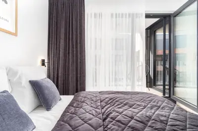 a bedroom with a bed and a large window at Prague Days - Premium Apartments - Balcony in Prague