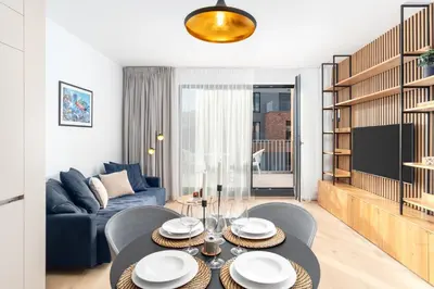 a living room with a table and a blue couch at Prague Days - Premium Apartments - Balcony in Prague