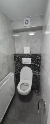a bathroom with a white toilet in a room at Vu's Home in Prague