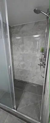 a shower with a glass door in a bathroom at Vu's Home in Prague