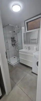 a bathroom with a shower and a toilet and a sink at Vu's Home in Prague