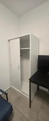 a white closet with a black table and a tv at Vu's Home in Prague