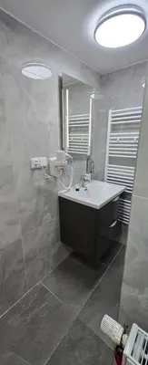 a bathroom with a sink and a mirror at Vu's Home in Prague